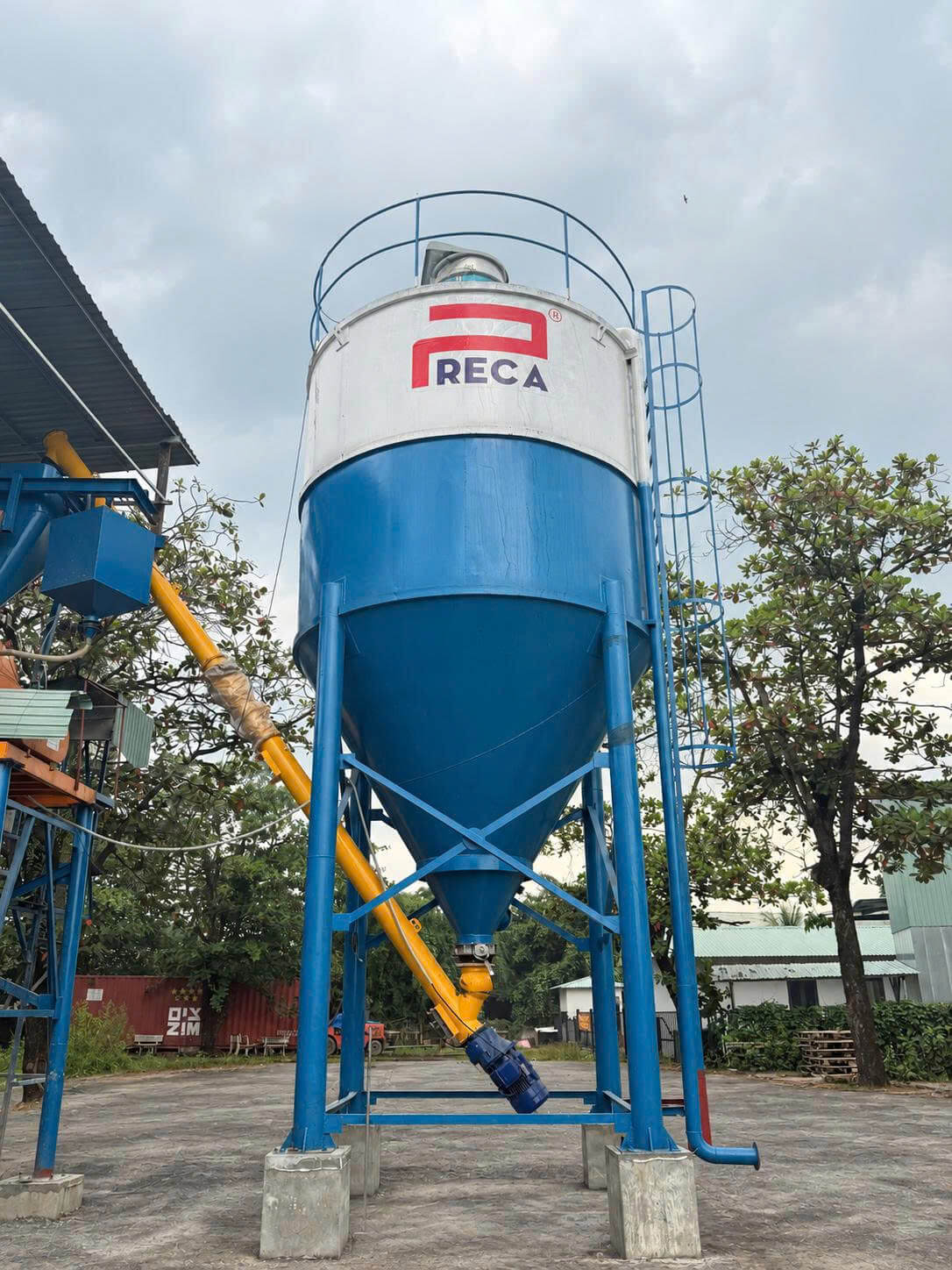 Hệ thống Silo lưu trữ xi măng và vít tải cấp liệu khép kín tại nhà máy.